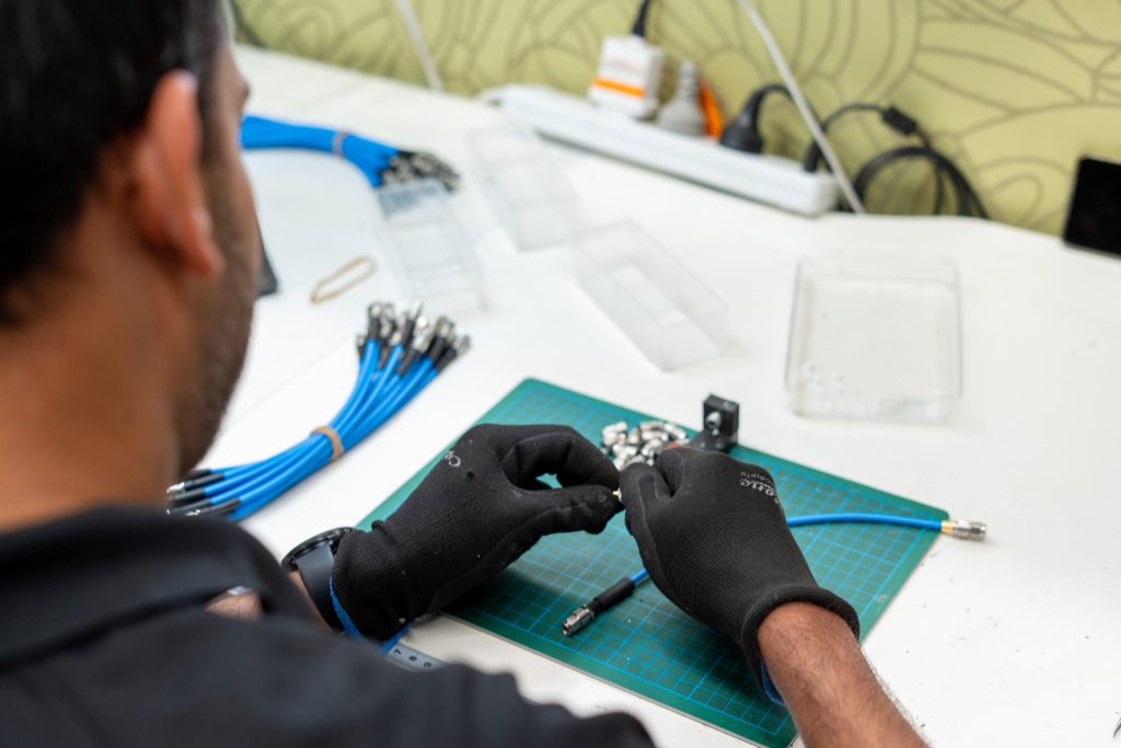 A technician who is assembling coaxial cables